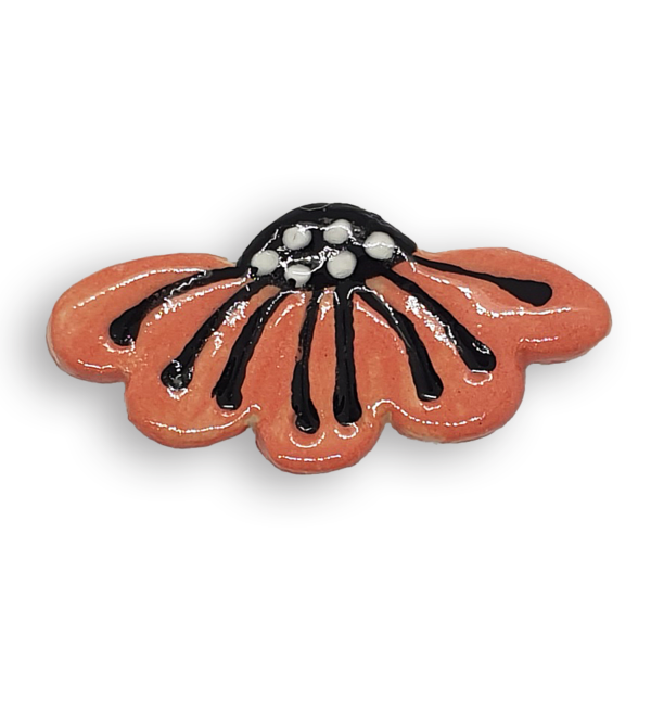 A hand-painted orange daisy flower ceramic mosaic insert with black and white details.