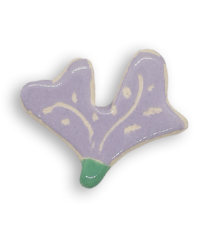 A hand-painted light purple petal-shaped ceramic mosaic insert with white designs.