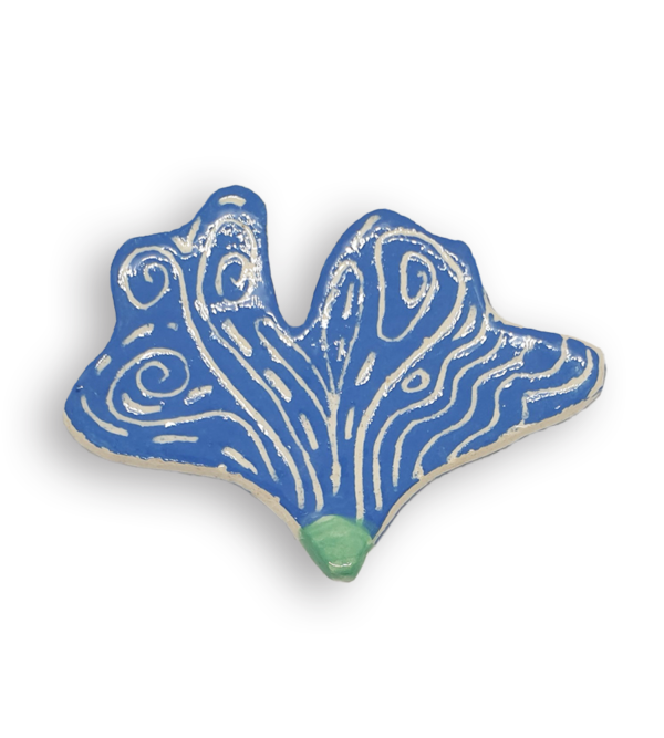 A hand-painted sky blue petal-shaped ceramic mosaic insert with white swirling designs.