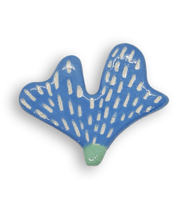 A hand-painted sky blue petal-shaped ceramic mosaic insert with a white pattern.