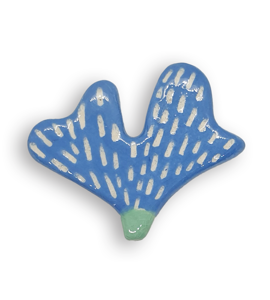 A hand-painted sky blue petal-shaped ceramic mosaic insert with a white pattern.