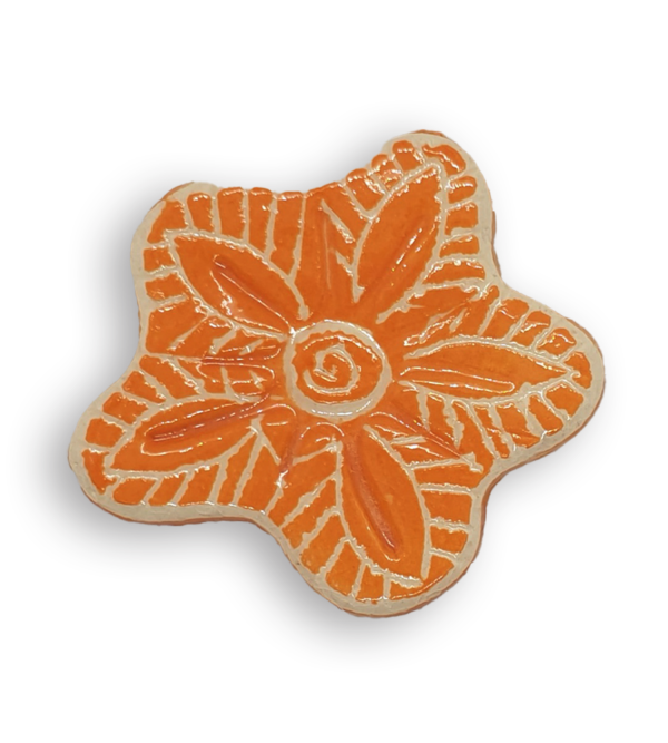 A hand-painted bright orange anemone ceramic mosaic insert with white swirling designs.