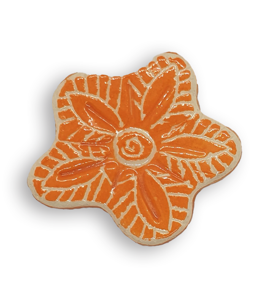A hand-painted bright orange anemone ceramic mosaic insert with white swirling designs.