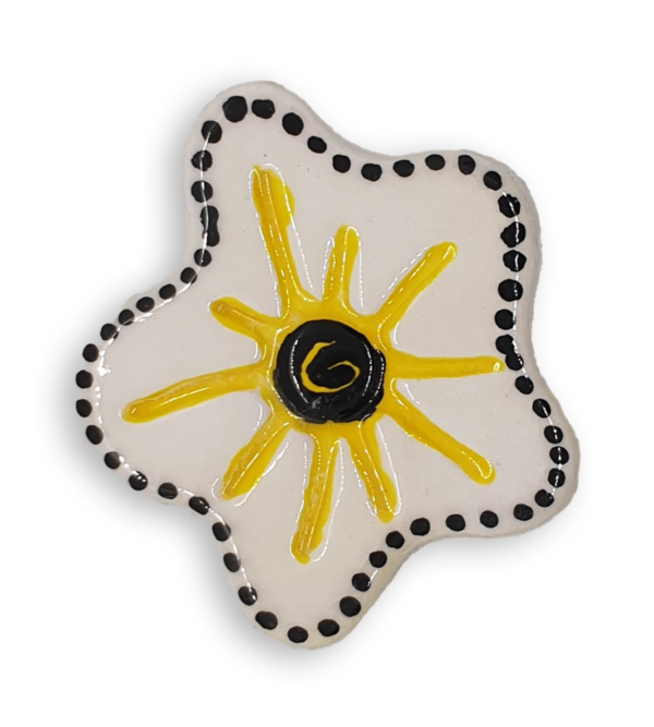 A hand-painted white anemone ceramic mosaic insert with a black spiral at the centre, a rim of black dots and yellow starburst design.