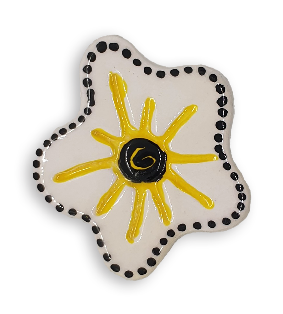 A hand-painted white anemone ceramic mosaic insert with a black spiral at the centre, a rim of black dots and yellow starburst design.