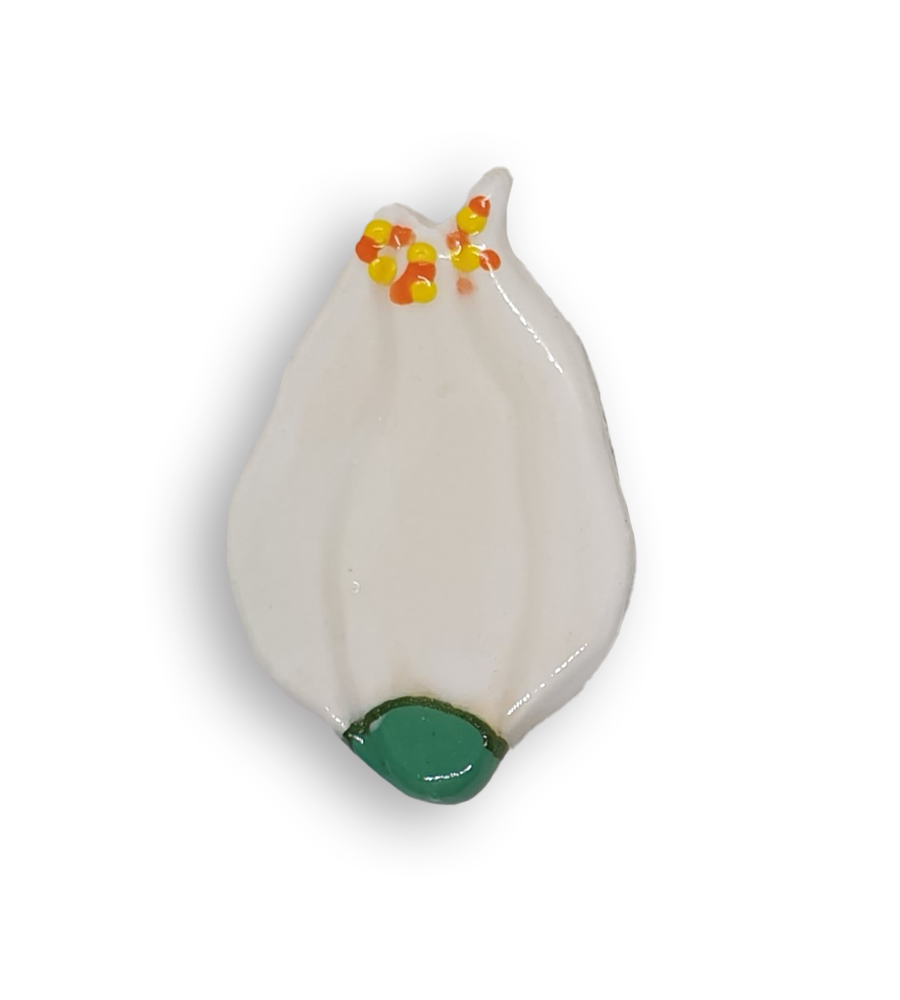 A hand-painted white flower ceramic mosaic insert with yellow and orange details in the shape of a tulip.
