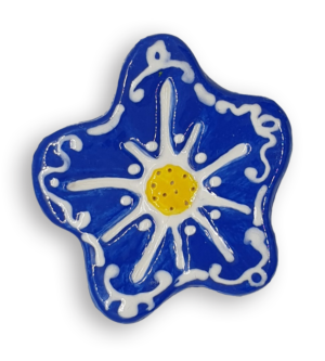 A hand-painted cobalt blue anemone ceramic mosaic insert with white swirling designs and a bright yellow centre.