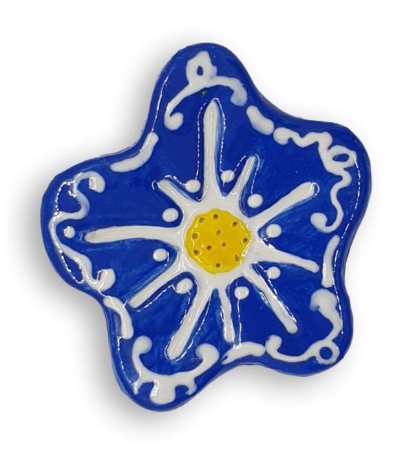 A hand-painted cobalt blue anemone ceramic mosaic insert with white swirling designs and a bright yellow centre.