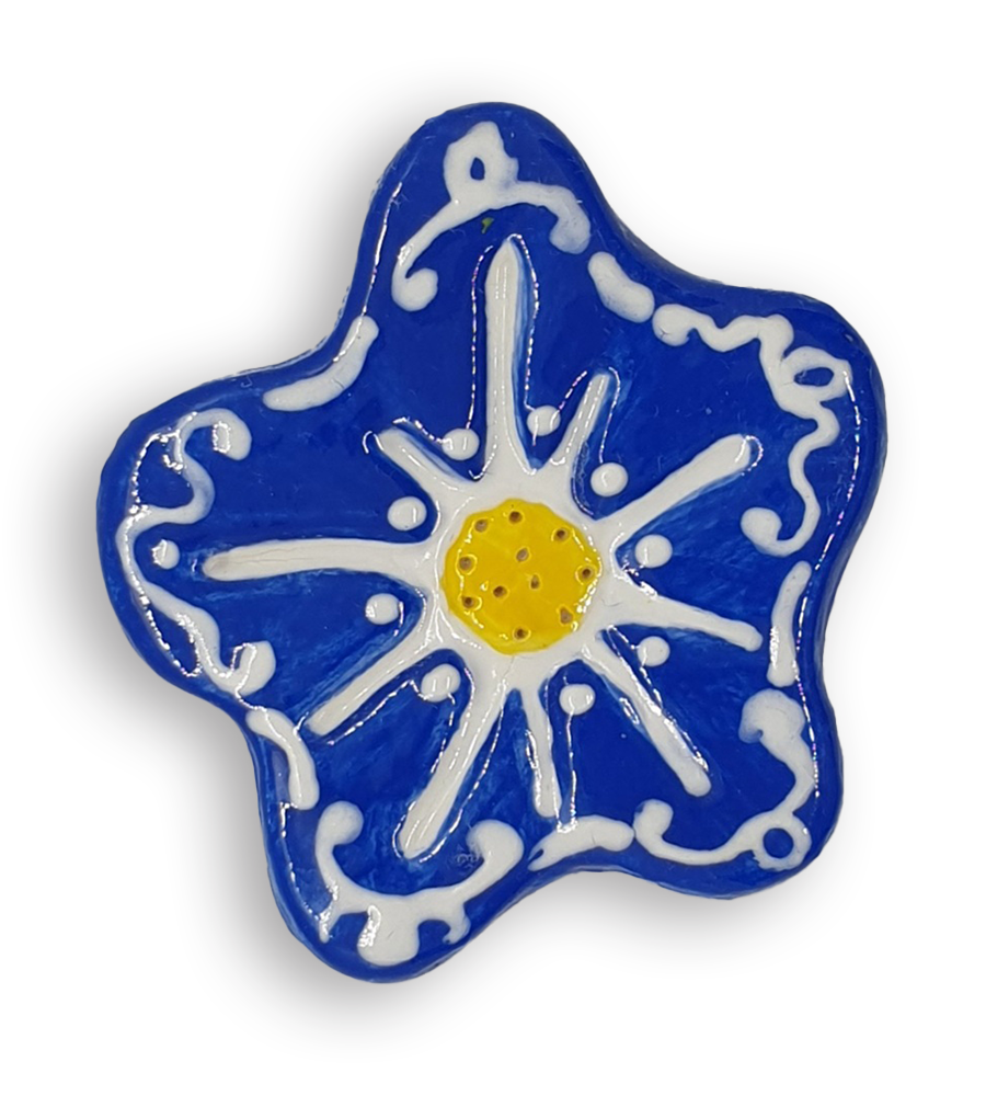 A hand-painted cobalt blue anemone ceramic mosaic insert with white swirling designs and a bright yellow centre.