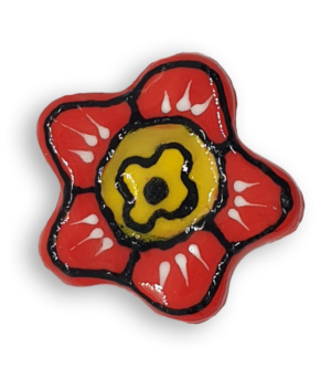 A hand-painted bright red anemone ceramic mosaic insert with black and white details and a yellow centre.