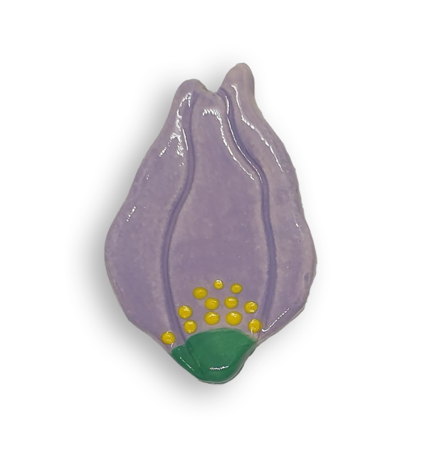 A hand-painted purple flower ceramic mosaic insert with yellow paint speckles at the flower's base.