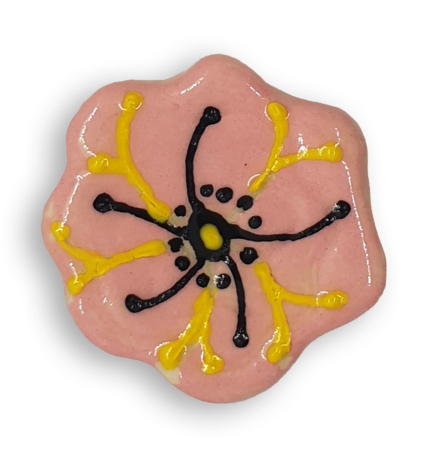 A pink flower ceramic mosaic insert with hand-painted black and yellow details.