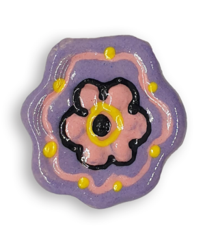 A mauve flower ceramic mosaic insert with hand-painted black, pink and yellow details.