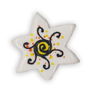 A white star-shaped ceramic mosaic insert with black, orange and yellow detailing.