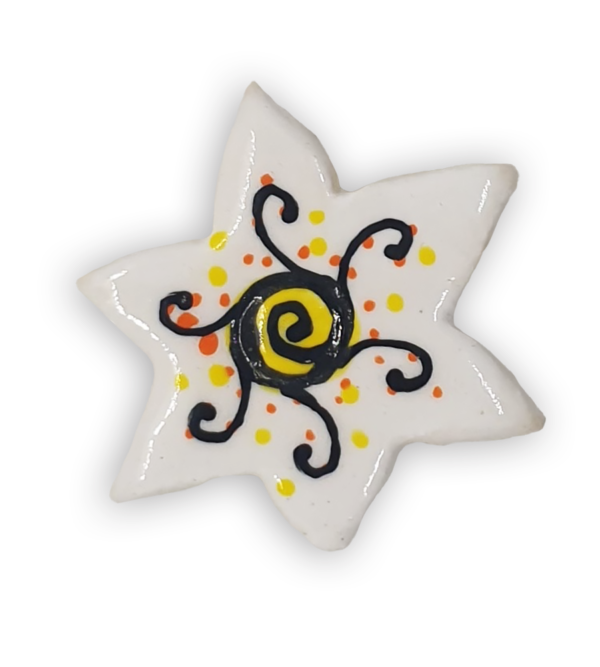 A white star-shaped ceramic mosaic insert with black, orange and yellow detailing.