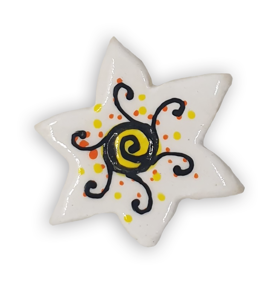 A white star-shaped ceramic mosaic insert with black, orange and yellow detailing.