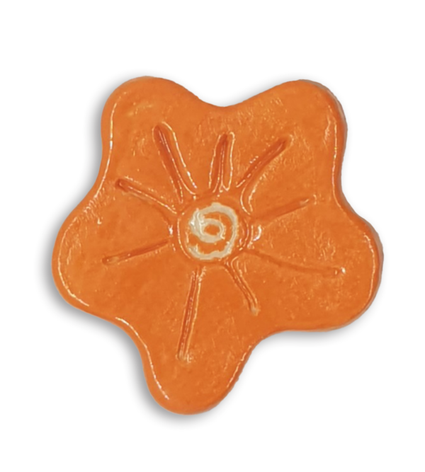 A hand-painted bright orange anemone ceramic mosaic insert with a white spiral at the centre.