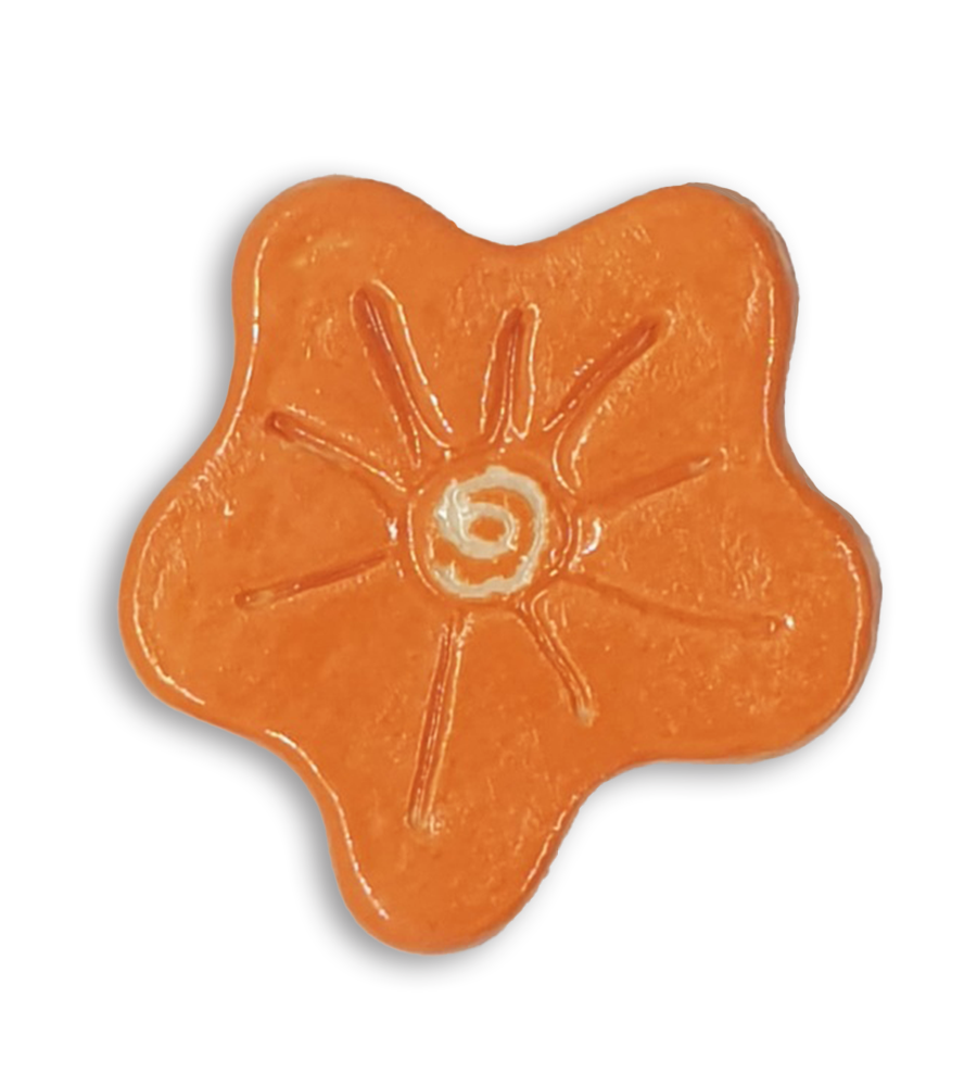 A hand-painted bright orange anemone ceramic mosaic insert with a white spiral at the centre.