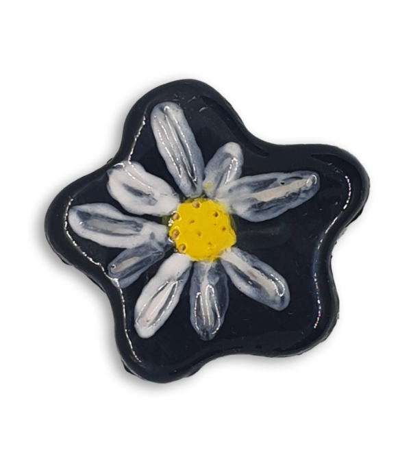 A simple black and white hand-painted anemone ceramic mosaic insert with a yellow centre.