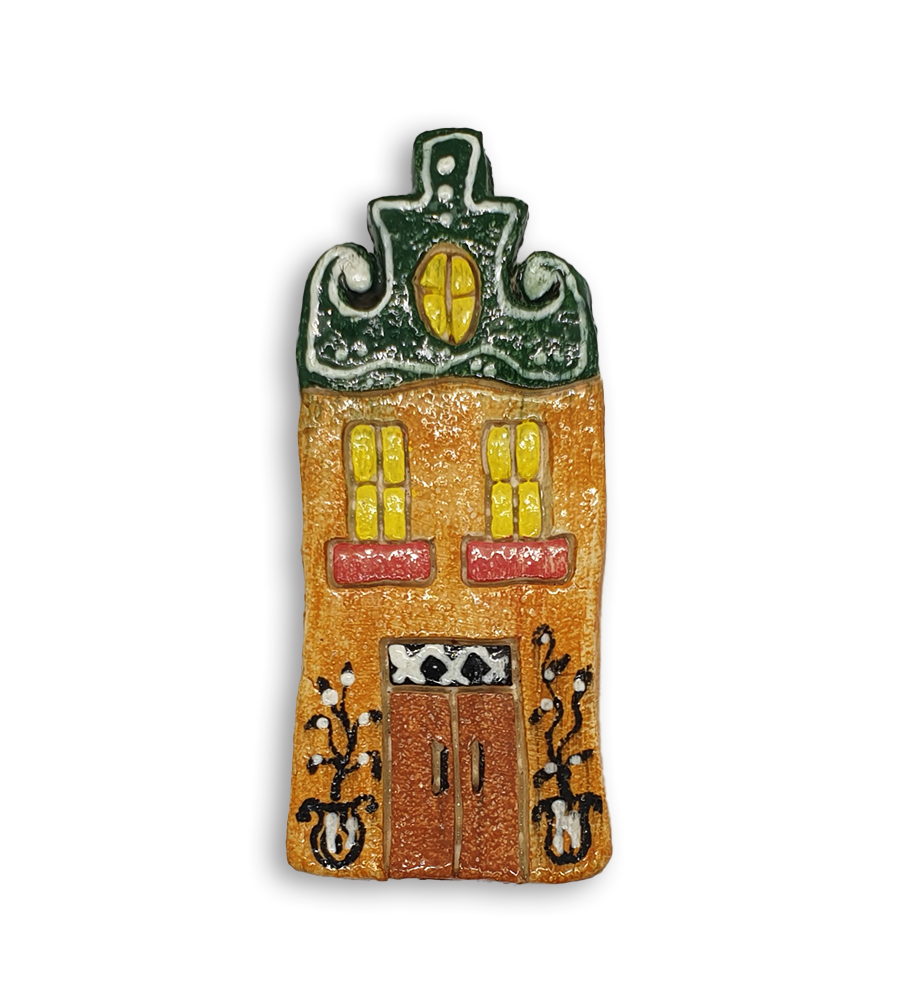 A hand-painted Dutch house ceramic mosaic insert with a green gabled roof.