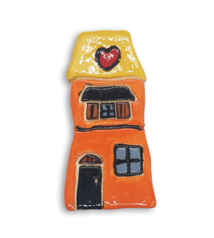 A hand-painted orange house ceramic mosaic insert with a yellow roof and red heart design.