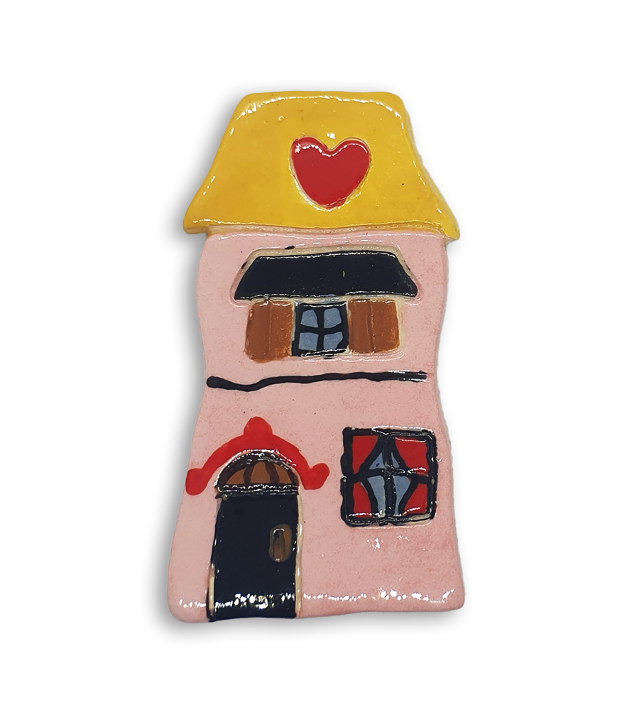 A hand-painted pink house ceramic mosaic insert with a heart design on the roof.