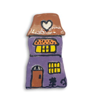 A hand-painted purple house ceramic mosaic insert with a heart design on the roof.