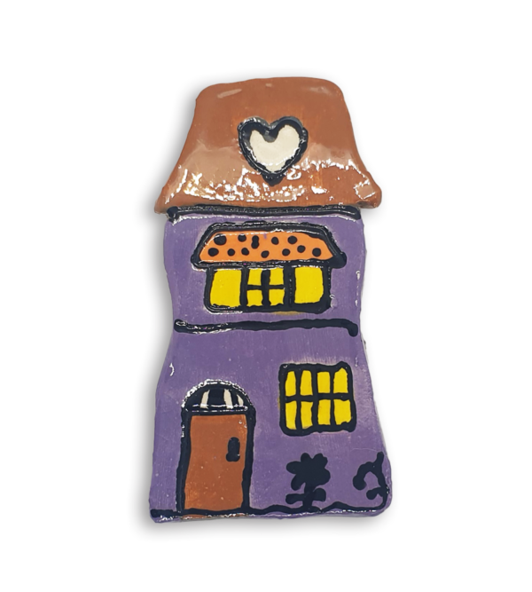 A hand-painted purple house ceramic mosaic insert with a heart design on the roof.