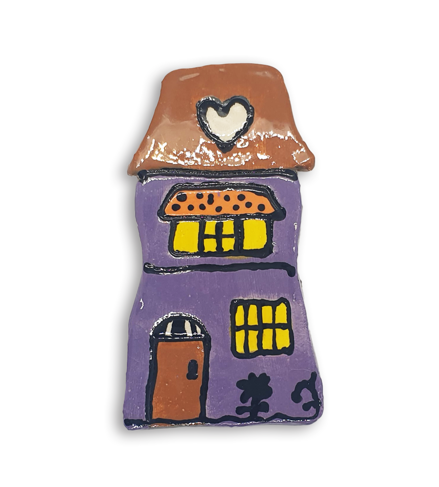 A hand-painted purple house ceramic mosaic insert with a heart design on the roof.