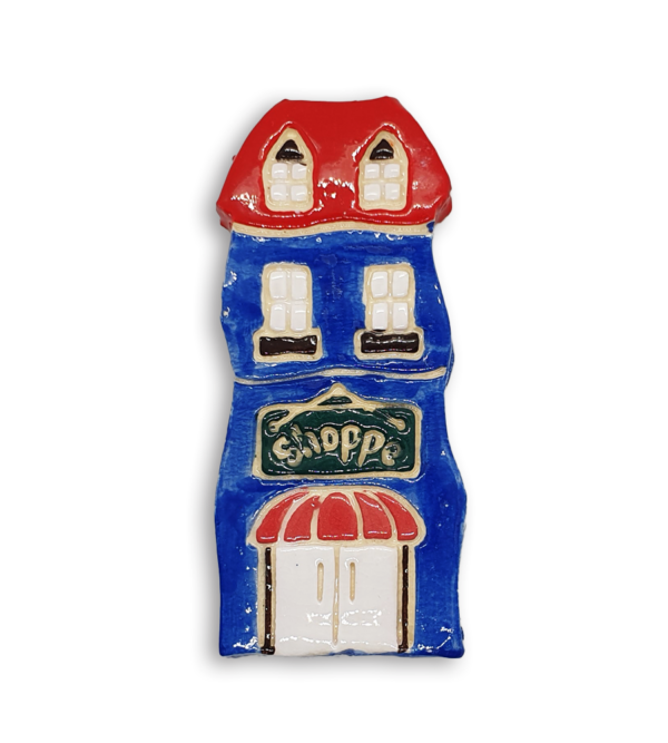 A hand-painted blue house ceramic mosaic insert with a red roof and old fashioned black Shoppe sign.