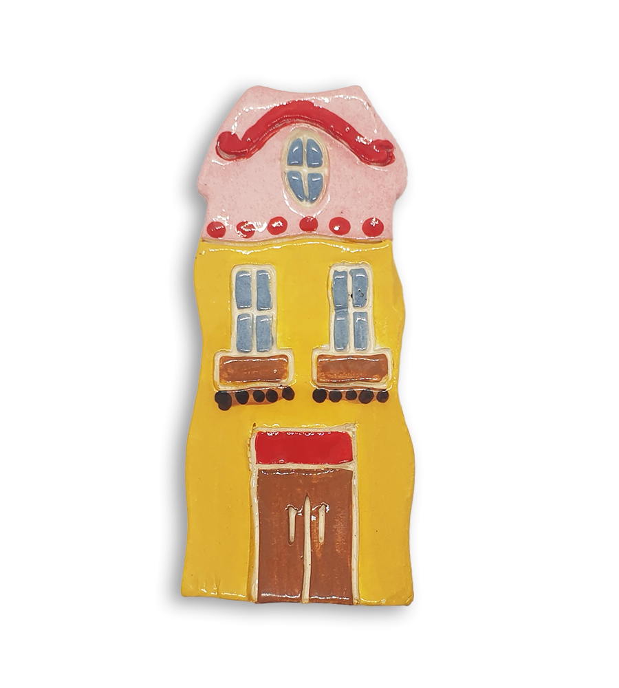 A hand-painted yellow Dutch house ceramic mosaic insert with a pink gabled roof.