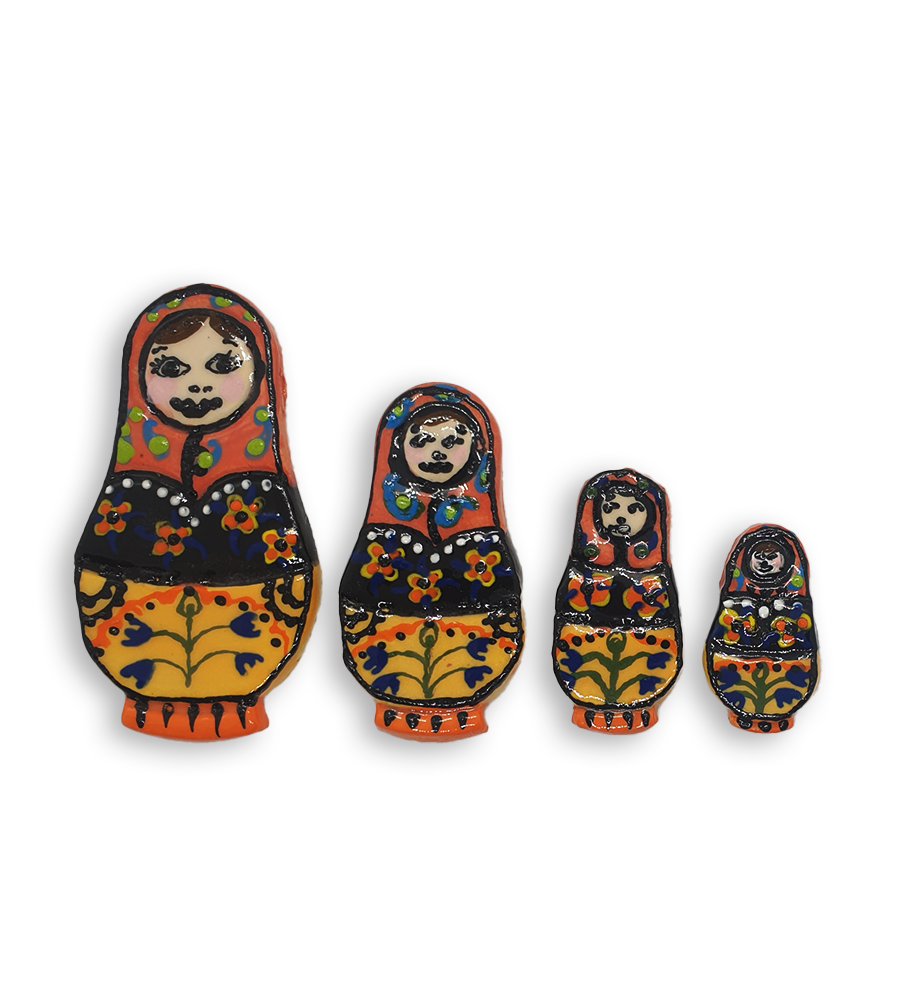 A set of three hand-painted Russian Doll ceramic mosaic inserts with black and yellow dresses and orange headscarves.
