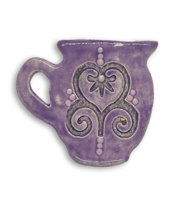 A hand-painted purple jug ceramic mosaic insert with a swirling heart design.