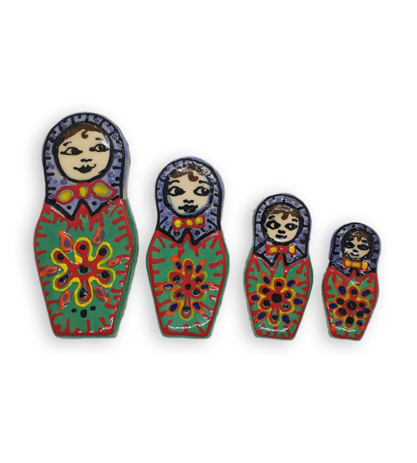 A set of four hand-painted Russian Doll ceramic mosaic inserts with green dresses and purple headscarves, and red edging.