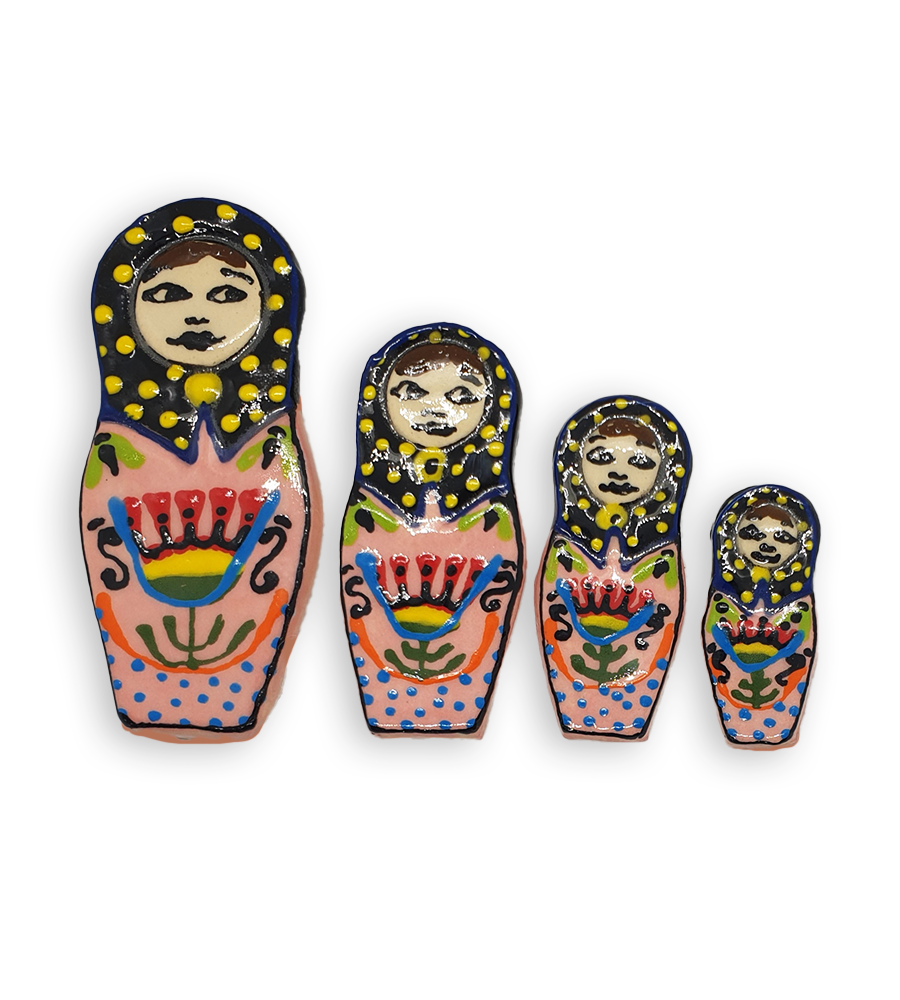 A set of four hand-painted Russian Doll ceramic mosaic inserts with pink dresses, black headscarves spotted with yellow and floral detail.