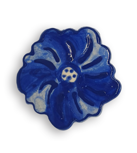A ceramic mosaic insert in the shape of a dark blue poppy flower.