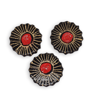 Three ceramic mosaic inserts in the shapes of black and red flowers.