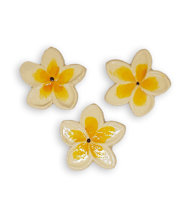 Three ceramic mosaic inserts in the shapes of tropical frangipani flowers.