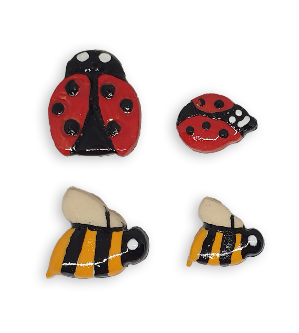 A selection of ceramic mosaic inserts in the shapes of ladybugs and bees.